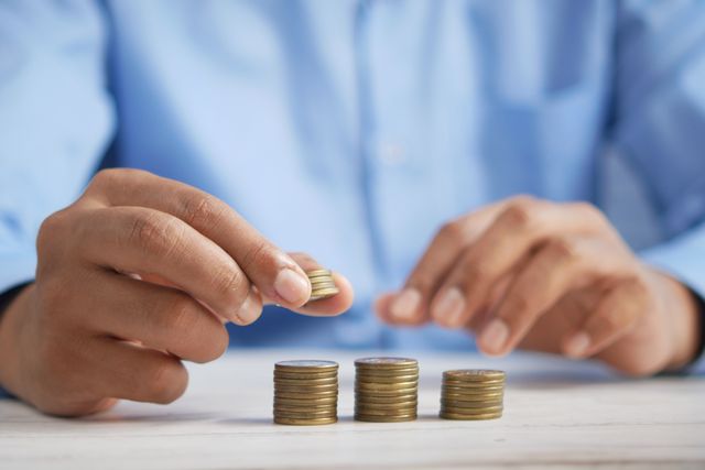 hands stacking gold coins
