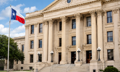 Pale stone courthouse with Texas flag