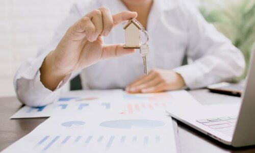 professional presenting a house model with keys